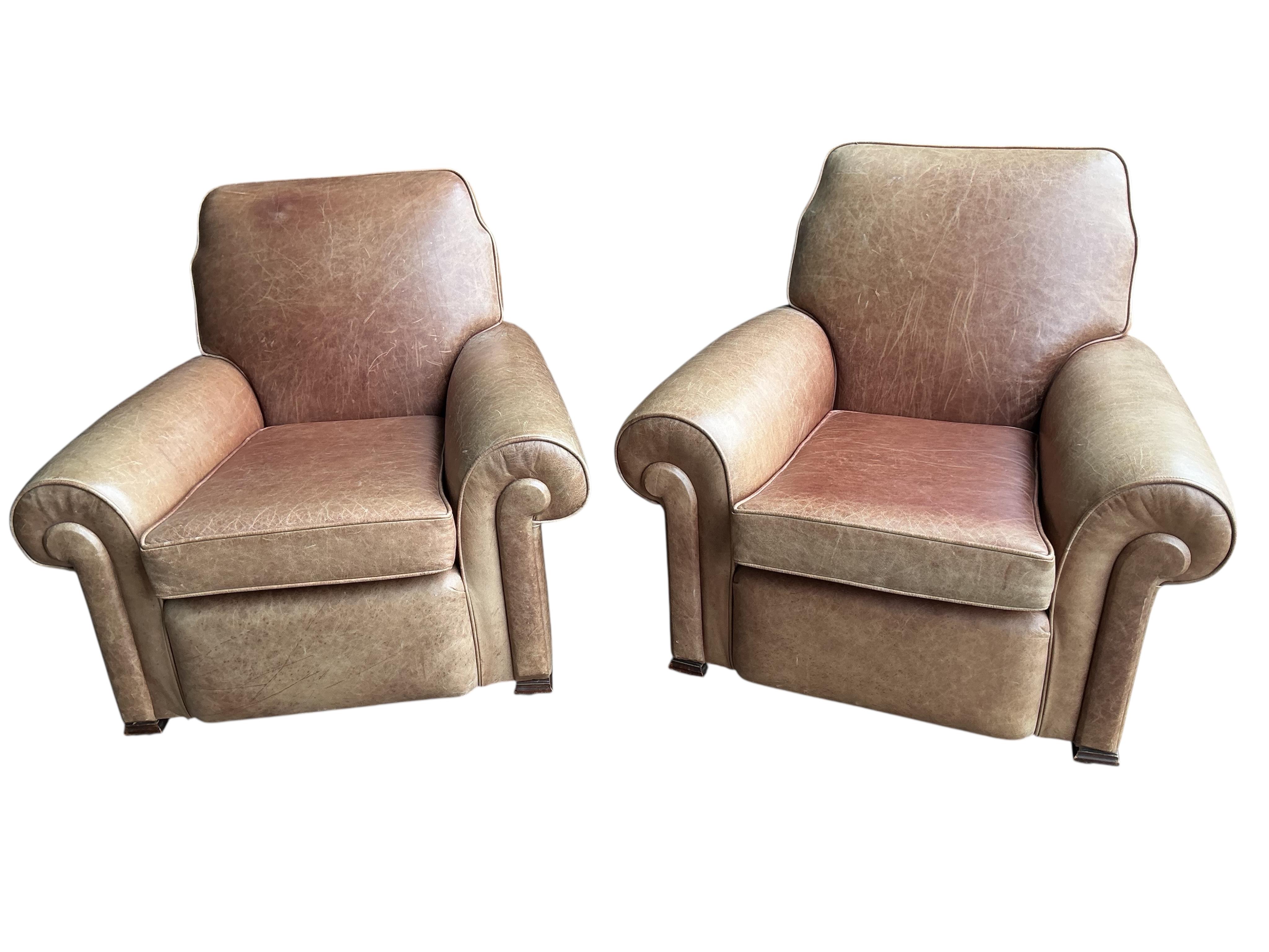 A pair of early 20th century tan leather club chairs, width 94cm, depth 78cm, height 80cm